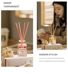 Glas-Raumdiffusor-Flasche mit rosa Stäbchen und Trockenblumen für Duftdekoration zu Hause.