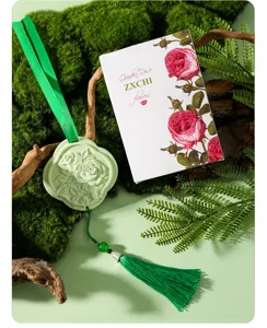 Detail shot of plaster aromatherapy diffuser stone pendant with green tassel and floral box.