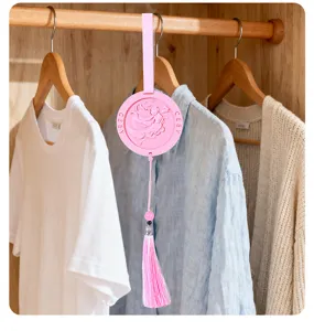 Detail shot of a pink plaster aroma hanging pendant with tassel for wardrobe and car decor.