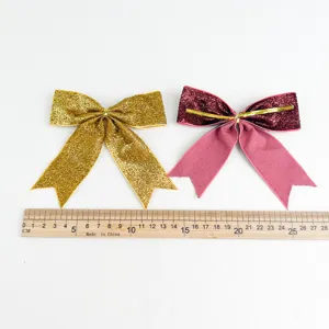 Vista dettagliata di fiocchi glitterati di Natale ornamenti sospesi con righello su sfondo bianco.