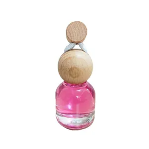 Car hanging perfume bottle aromatherapy diffuser pendant with pink liquid and wood cap.