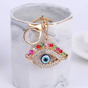 Close-up of sparkling evil eye rhinestone keychain, metal alloy car pendant bag accessory.