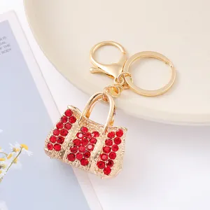 Gros plan détail d'un élégant porte-clés sac à main en strass avec cristaux rouges brillants.