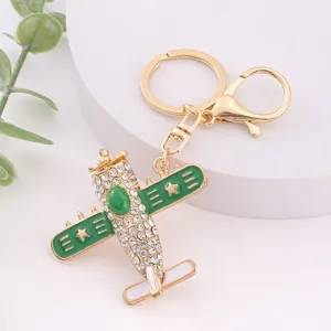 Gedetailleerde close-up van strass vliegtuig sleutelhanger, groene emaille kristal metalen hanger.