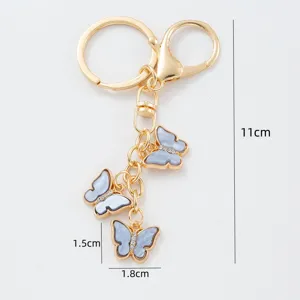 Golden metal keychain with light blue butterfly charms, cute bag pendant and car keyring accessory.