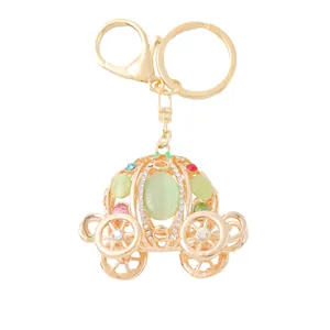 Gold pumpkin carriage keychain with rhinestones and green cat eye stone, fashion bag pendant.