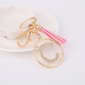 Detailed close-up of the metal rhinestone letter C key chain with pink tassel accessory.
