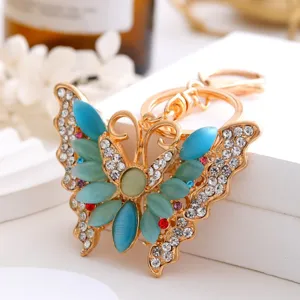 Porte-clés papillon en métal exquis avec des strass étincelants et des pierres œil-de-chat bleues.