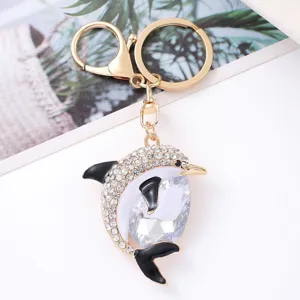 Close-up detail of the sparkling rhinestone dolphin keychain with gold metal hardware and hook.