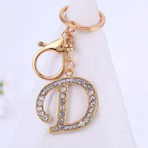 Close-up of gold rhinestone letter D keychain pendant, sparkling crystal jewelry detail.