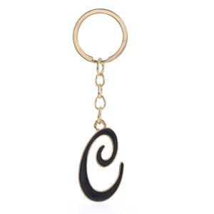 Close-up view of elegant gold metal and black letter C keychain pendant accessory.
