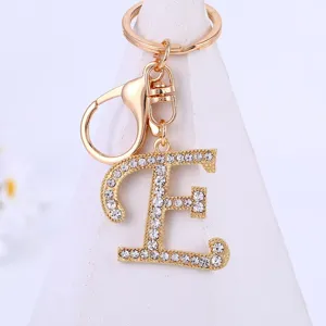 Rhinestone letter E keychain detail, gold alloy metal finish, sparkling crystal charm pendant.