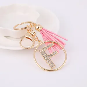 Detail view of the sparkly rhinestone letter F charm with soft pink tassel keychain.