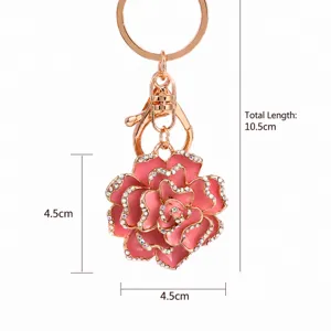 Close-up detail of the pink enamel rose flower keychain with sparkling rhinestones and gold hardware.
