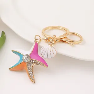 Closeup of vibrant enamel starfish and shell keychain with sparkling rhinestones and metal ring.