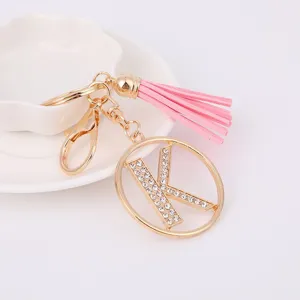 Detailed close-up view of the gold rhinestone letter K keychain with pink leather tassel.