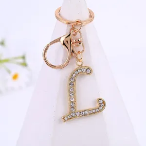 Gold alloy rhinestone letter L keychain pendant close-up, sparkling crystal initial charm.