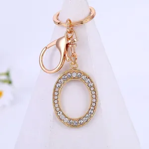 Gold rhinestone letter O keychain pendant detail, sparkling crystal alphabet keyring accessory.