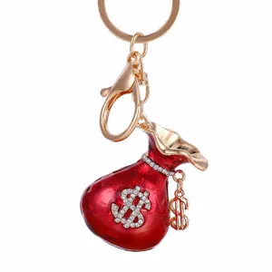 Vue détaillée d'un porte-clés bourse rouge vif orné de strass étincelants et d'accessoires dorés.