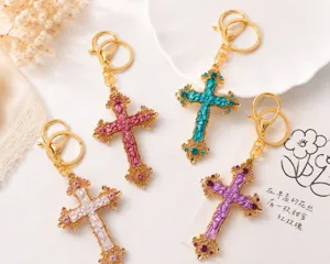 Detail van de vintage geëmailleerde strass kruis sleutelhanger in kleurrijke legering.