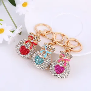 Close-up detail of sparkling rhinestone heart fortune bag keychains with colorful bows.