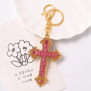 Gedetailleerd opname van vintage strass kruis sleutelhanger met roze kristallen.