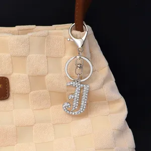 Silver rhinestone letter keychain detail shot, sparkling metal pendant for bags and keys.