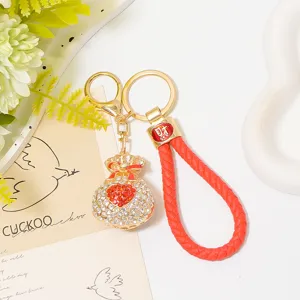 Rhinestone heart shaped lucky bag keychain charm with red braided leather strap detail