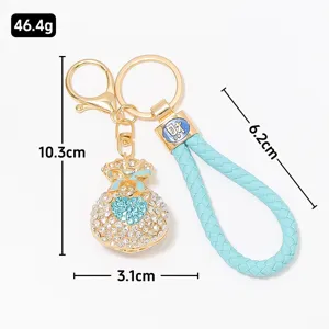 Rhinestone lucky bag keychain with blue heart crystal and leather braided strap for keys.