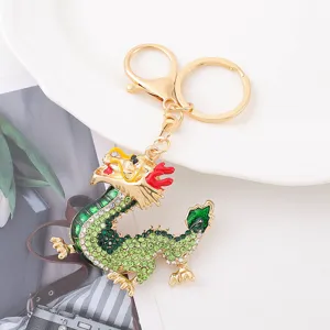 Detailed view of Chinese zodiac dragon keychain, gold metal with green rhinestones and enamel.