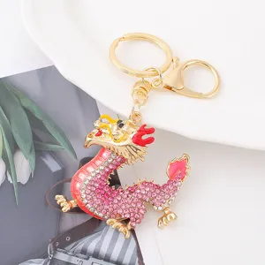 Close-up detail view of the sparkling rhinestone dragon keychain with gold finish.