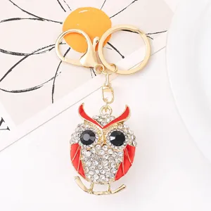 Detailopname van uil sleutelhanger met strass steentjes, gouden metaallegering en glans.