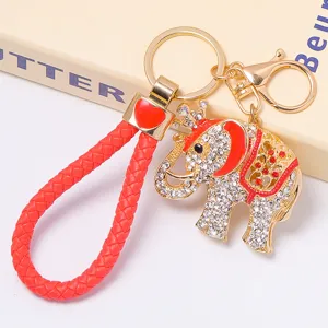 Porte-clés éléphant couronne en strass avec lanière tressée rouge et anneau doré.