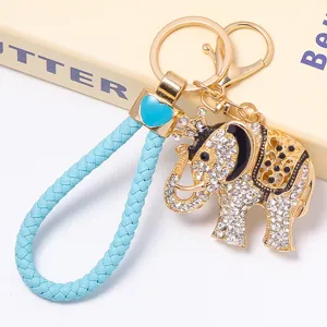 Gros plan détaillé du porte-clés éléphant couronne strass luxueux avec lanière tressée bleue.