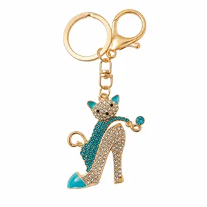 Primo piano portachiavi gatto tacco alto strass dorato, ciondolo luccicante per borsa alla moda.