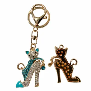 Dettaglio portachiavi gatto tacco alto in strass, ciondolo borsa in metallo di lusso chic.