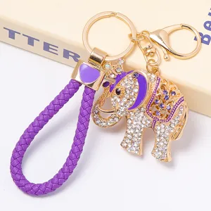 Porte-clés éléphant en cristal de luxe avec lanière tressée violette et anneaux dorés.