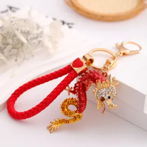 Red dragon keychain with rhinestone and braided leather strap, metal zodiac key ring pendant.