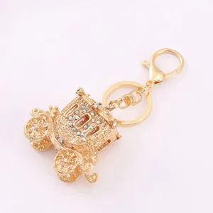 Detailed view of gold rhinestone pumpkin carriage keychain, sparkling crystal alloy charm accessory.