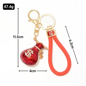 Porte-clés sac d'argent dollar rouge avec lanière en cuir et strass métalliques.