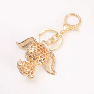 Gold tone metal puppy keychain with cute long ears and hollow clover pattern charm pendant.