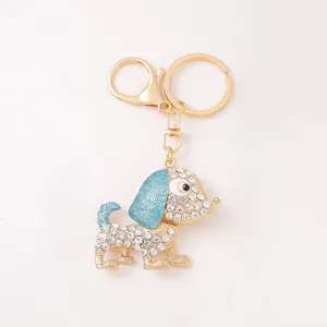 Close up detail of the sparkling rhinestone metal dog keychain with shiny gold and blue finish.