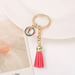 Gold metal keychain with pink leather tassel and colorful rhinestone letter L charm pendant.