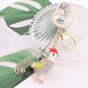Close up of crystal rhinestone rooster keychain, metal zodiac chick pendant detail shot view.