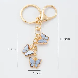 Gold metal butterfly keychain with rhinestones and elegant resin charms, chic accessory.