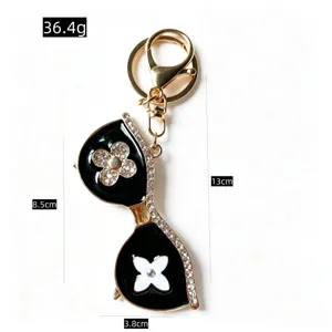 Rhinestone sunglasses keychain, luxury black and gold flower bag charm accessory for keys.