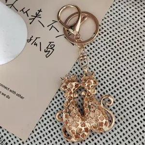 Portachiavi gatti di coppia in metallo dorato dettaglio, ciondolo per borsa elegante.