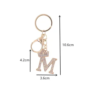 Rhinestone letter M keychain detail, dazzling crystal crown design on durable alloy metal.