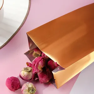 Nahaufnahme eines mattgoldenen Seitenfaltenbeutels aus Aluminiumfolie mit Rosen