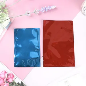 Zwei farbige Metallic-Folienflachbeutel in Blau und Rot auf rosa Blumenhintergrund.